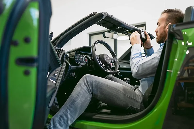 Markus Fronius fotografiert das Cockpit eines Audis